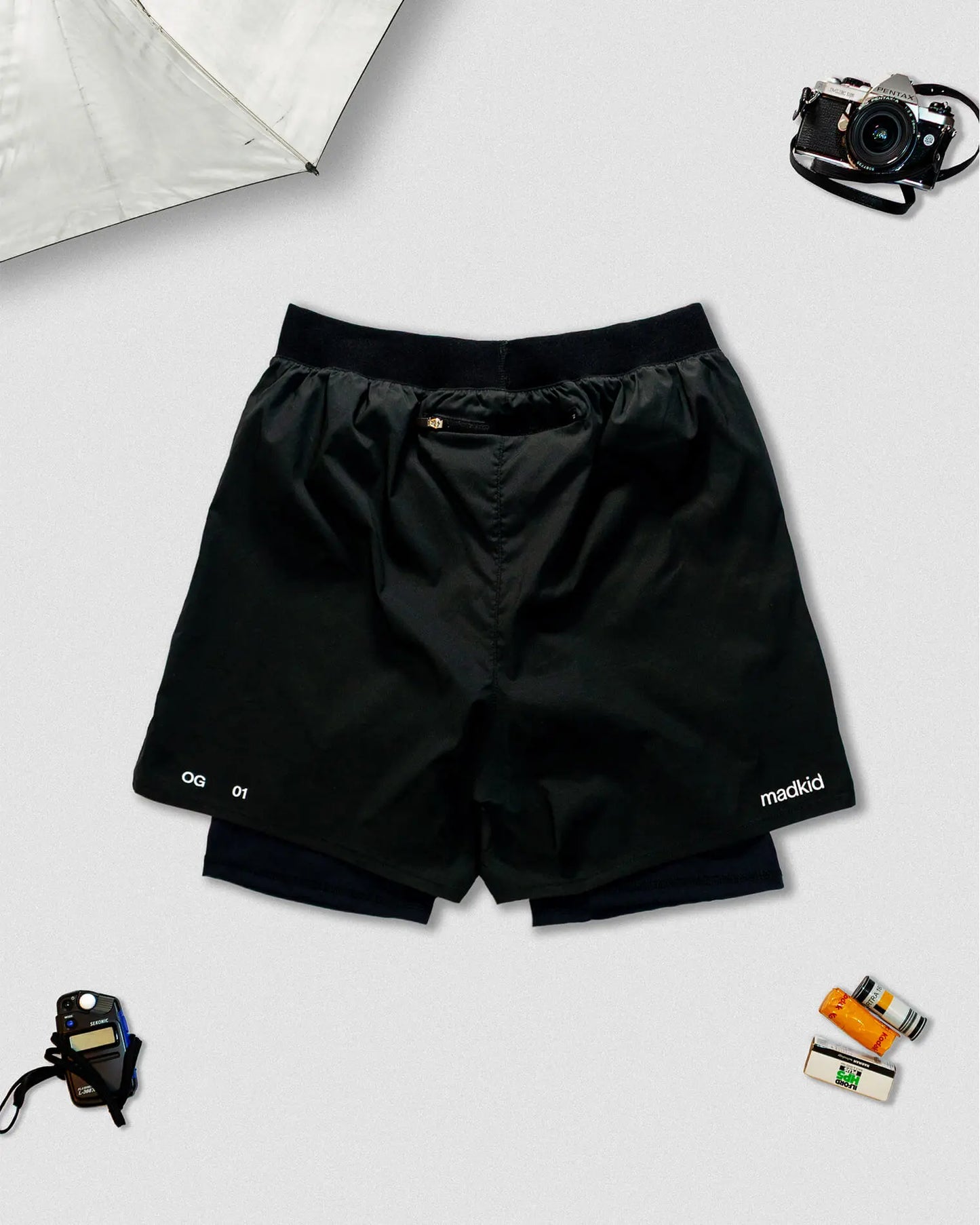 OG 01 men’s 2-in-1 shorts back view — lightweight black dual-layer shorts featuring elastic waistband and printed details by Madkid