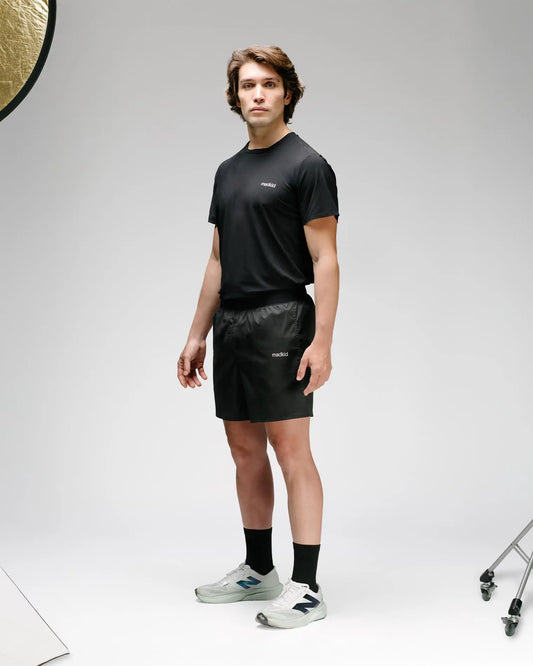 OG 01 men’s shorts side view — black technical shorts worn with Madkid tee, showing fit and lightweight fabric