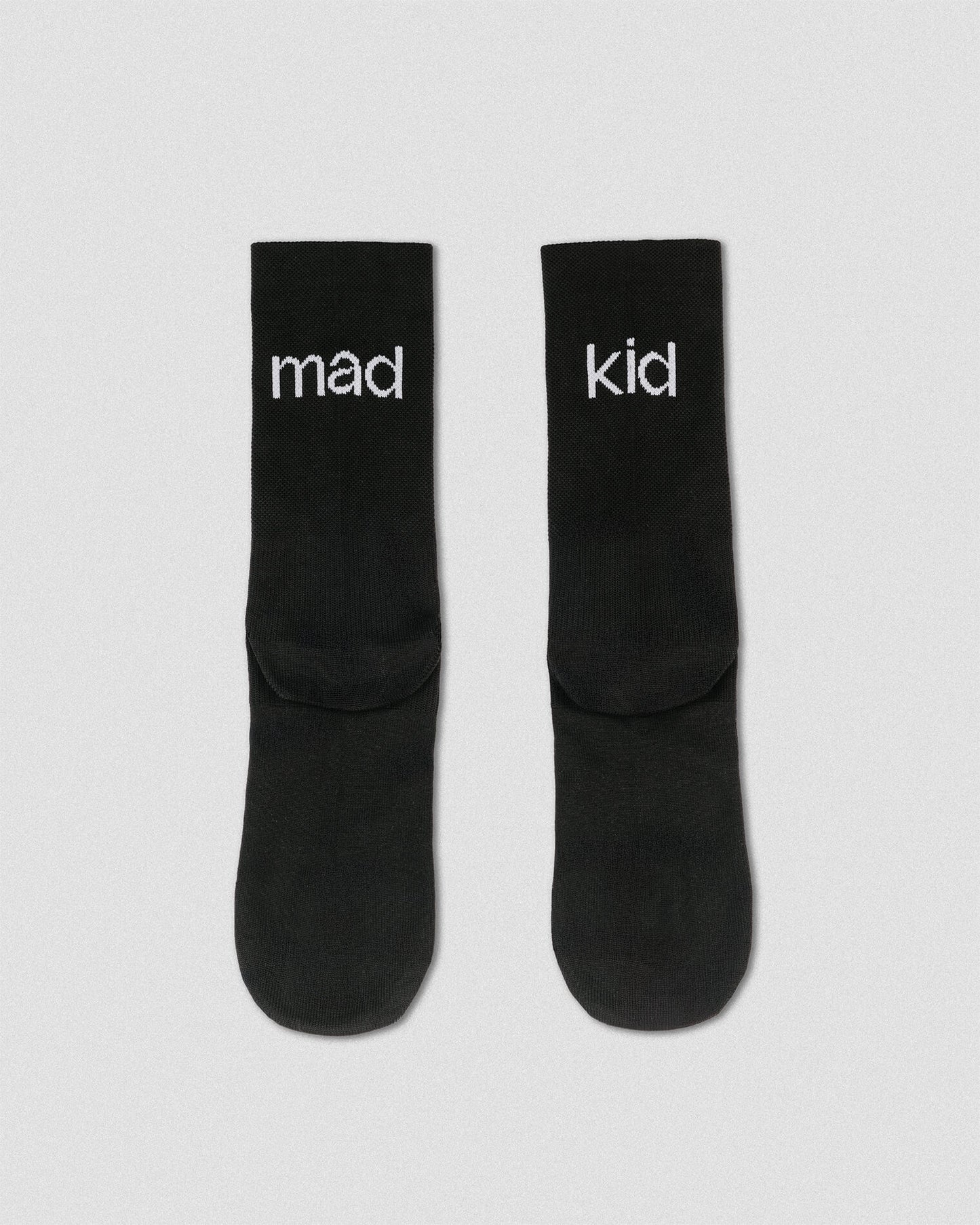 OG 01 black socks back flatlay — black socks showing “mad kid” wordmark on heel area