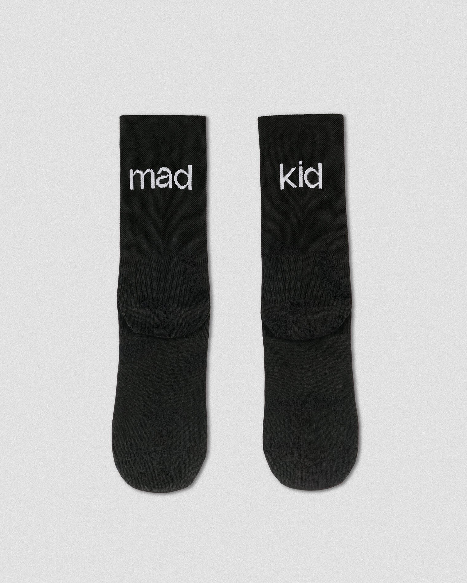 OG 01 black socks back flatlay — black socks showing “mad kid” wordmark on heel area