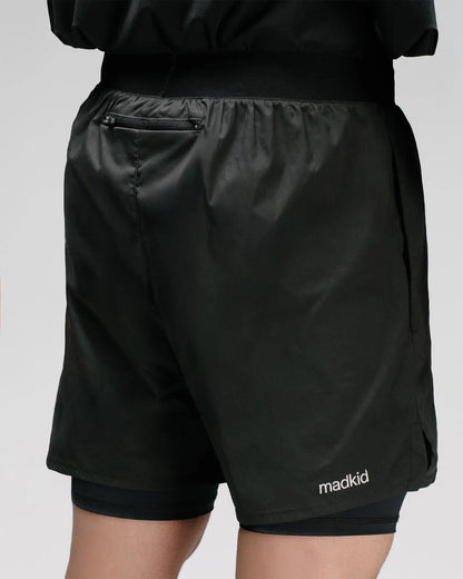 OG 01 men’s 2-in-1 shorts back on model — rear zip pocket and Madkid logo printed on lightweight black technical fabric
