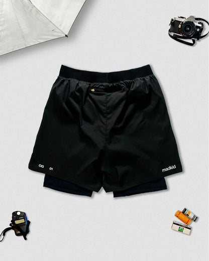 OG 01 men’s 2-in-1 shorts back view — lightweight black dual-layer shorts featuring elastic waistband and printed details by Madkid