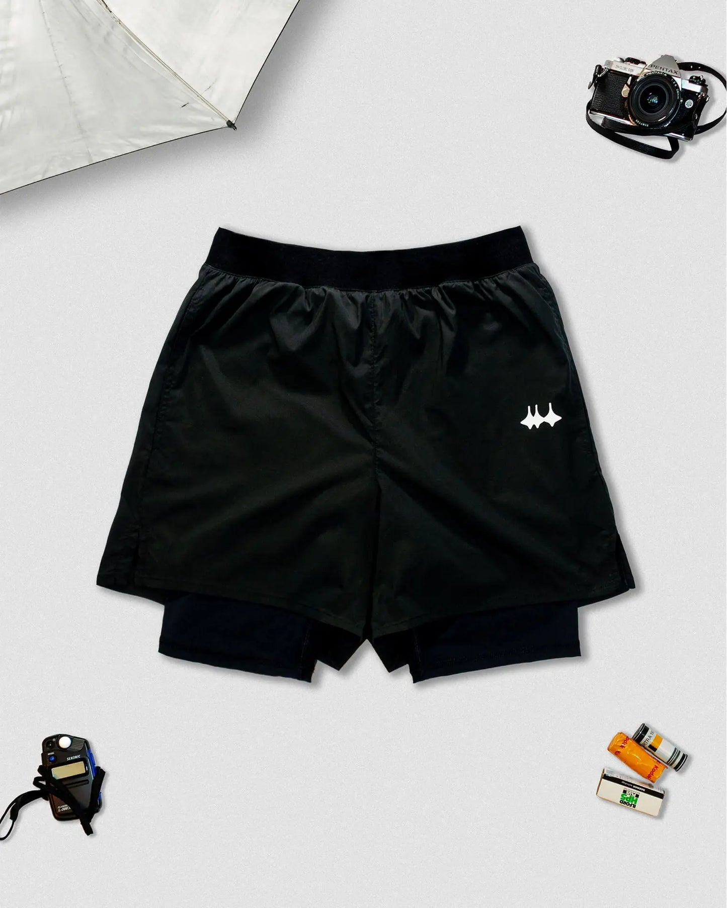 OG 01 men’s 2-in-1 shorts front view — black double-layer technical shorts with reflective logo by Madkid