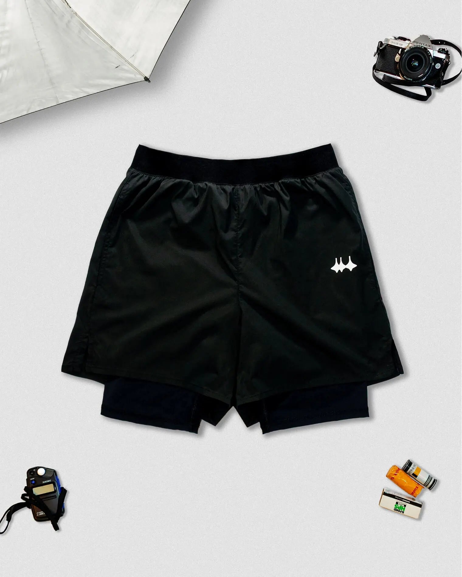 OG 01 men’s 2-in-1 shorts front view — black double-layer technical shorts with reflective logo by Madkid