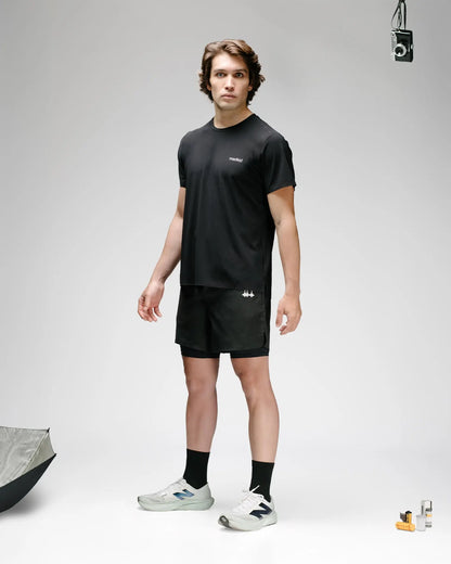 OG 01 men’s 2-in-1 shorts front view on model — black double-layer performance shorts worn with Madkid tee