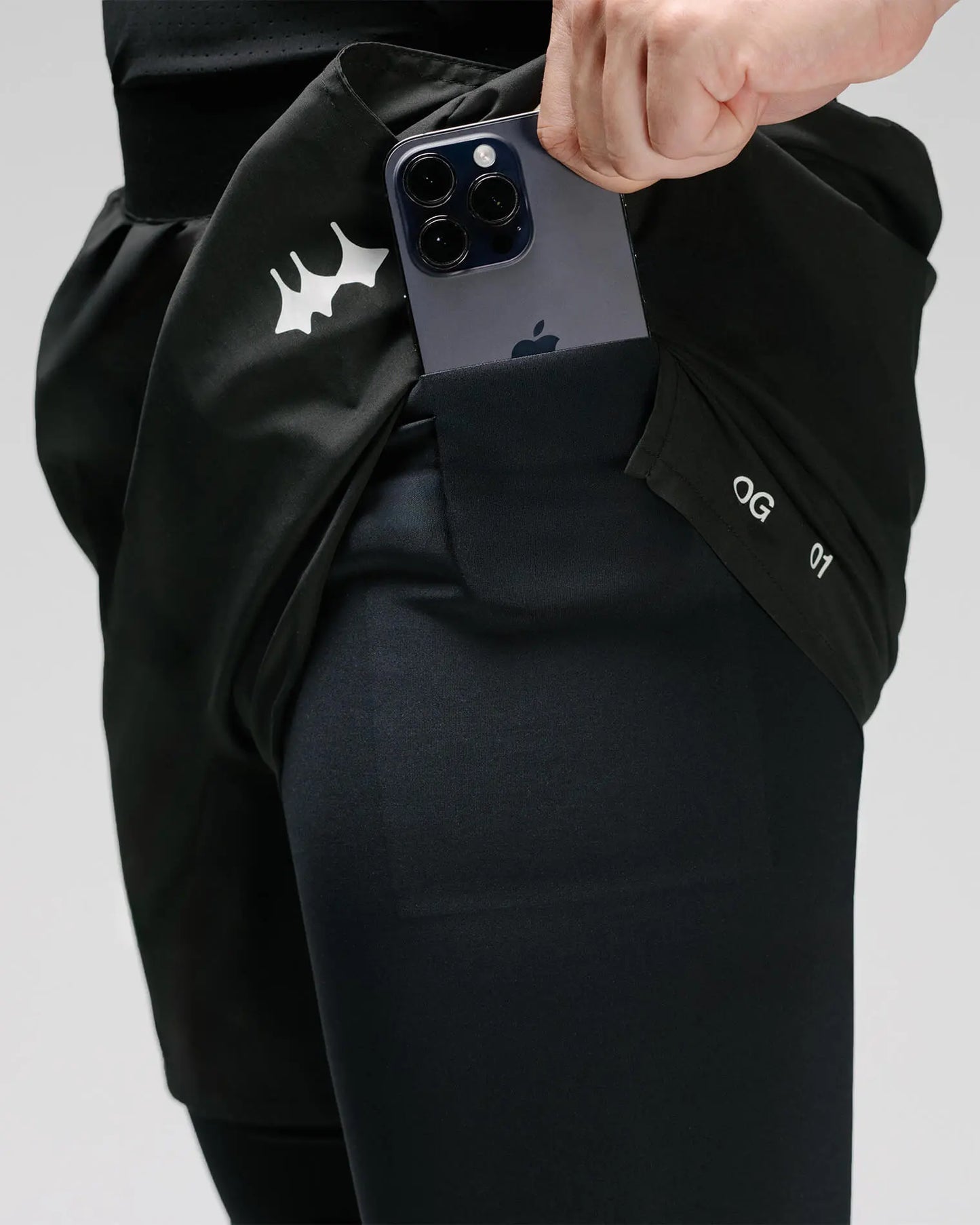 OG 01 men’s 2-in-1 shorts pocket feature on model — functional phone pocket integrated into inner layer