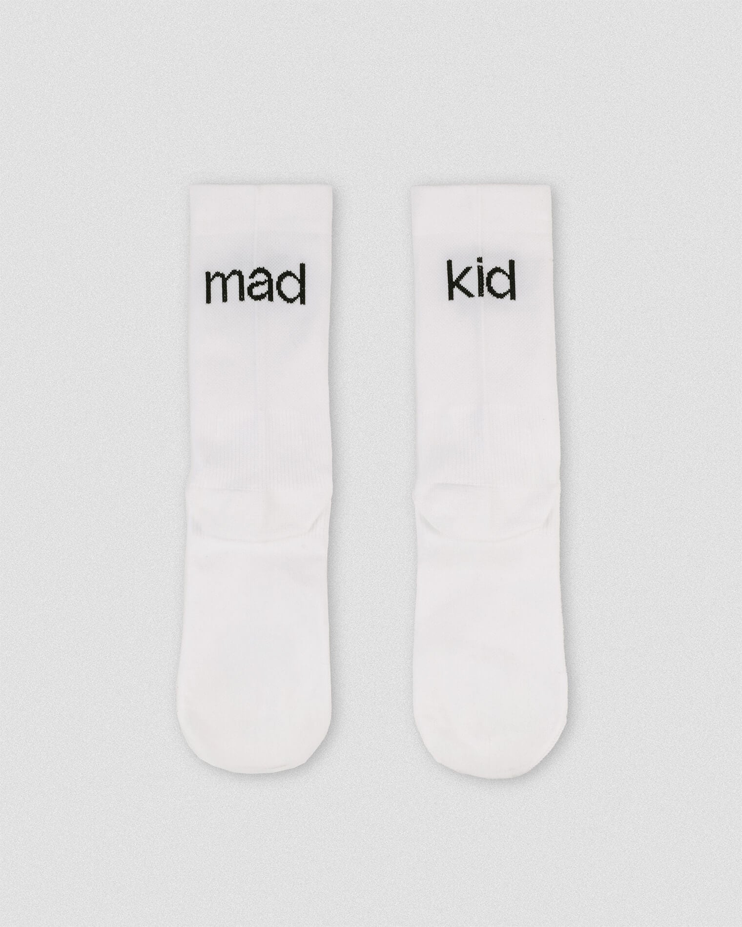 OG 01 white socks back flatlay — white athletic socks showing madkid lettering on back side