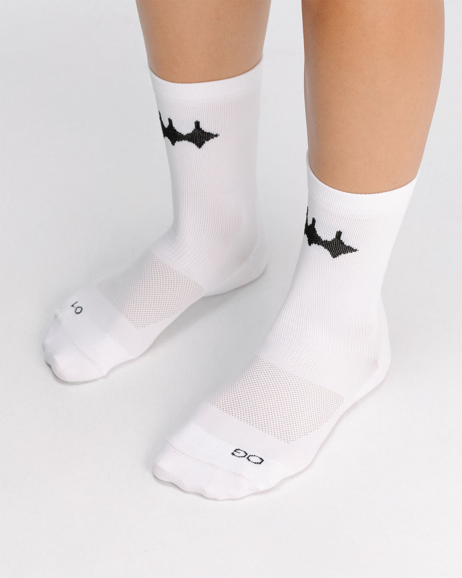 OG 01 white socks worn front on model — white crew socks with logo visible on front ankle area