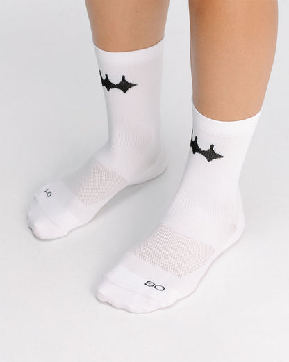 OG 01 white socks worn front on model — white crew socks with logo visible on front ankle area