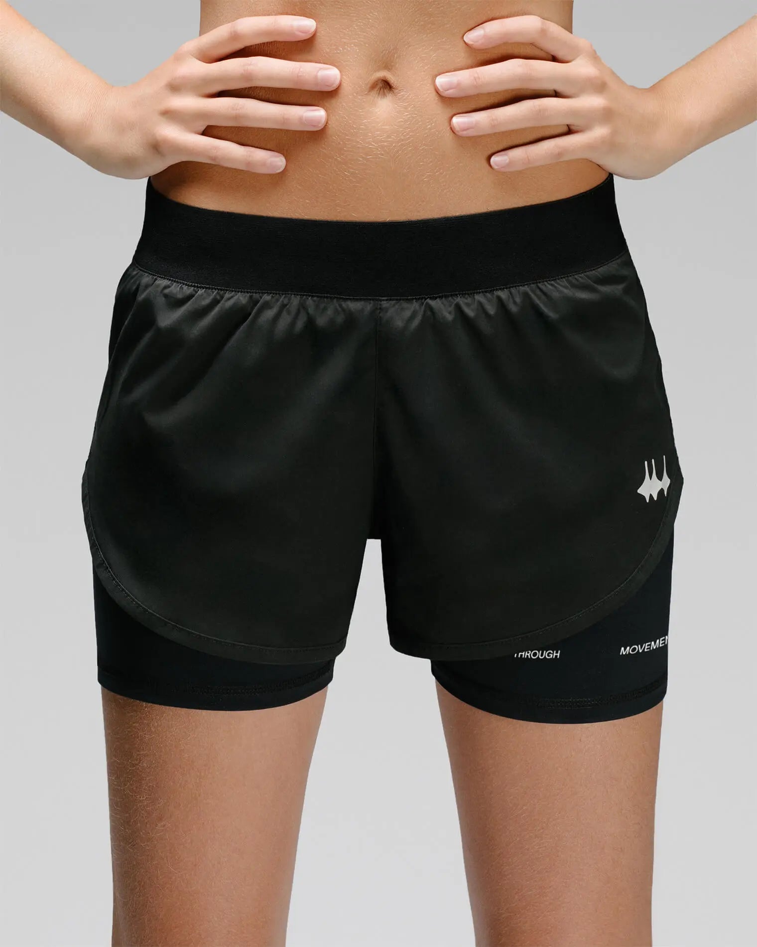 OG 01 women’s 2-in-1 shorts front on model — high-waisted double-layer design with reflective Madkid logo