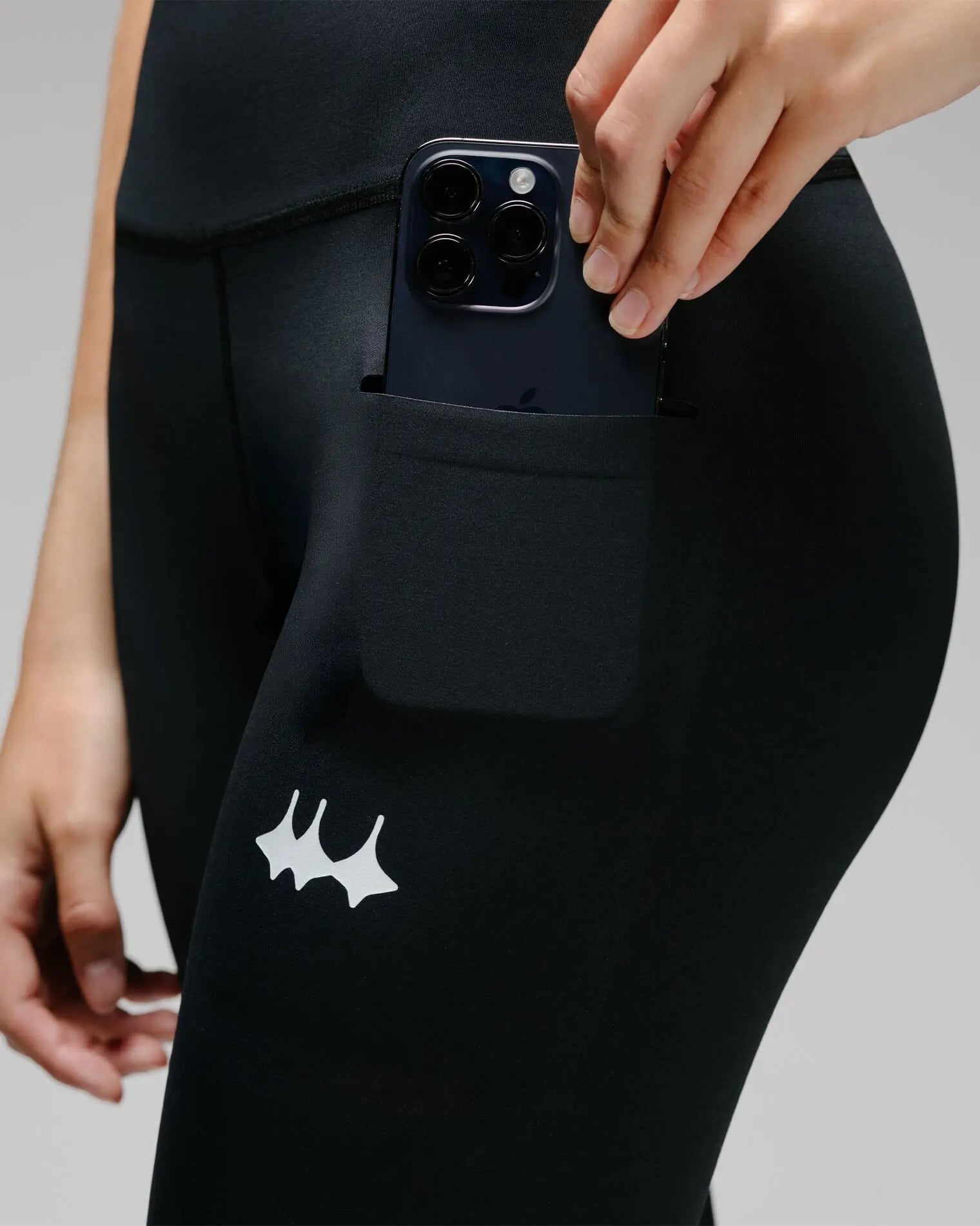 OG 01 women’s performance leggings pocket feature on model — functional phone pocket integrated on side panel with reflective logo