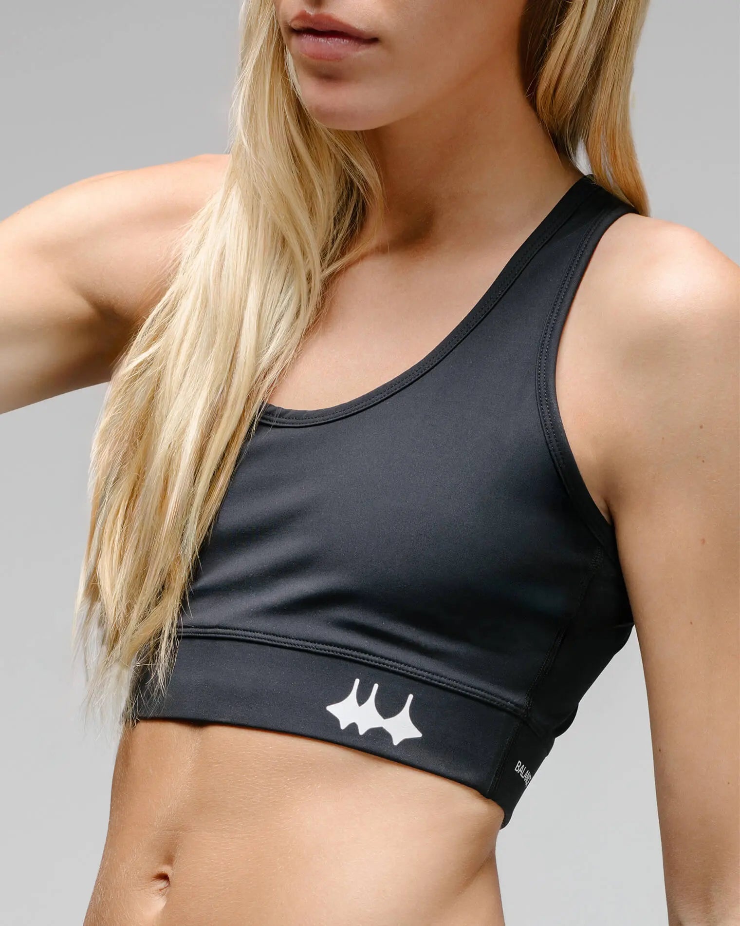 OG 01 women’s performance top side on model — angled view highlighting fabric texture and logo placement