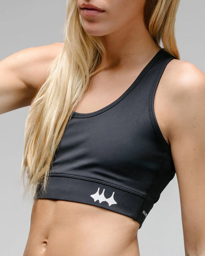 OG 01 women’s performance top side on model — angled view highlighting fabric texture and logo placement